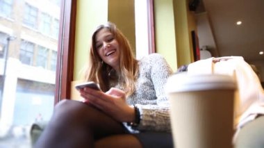 Woman in a cafe texting on the phone