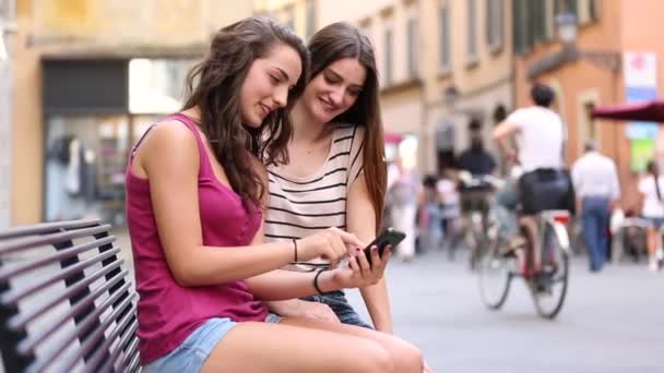 Two girls looking at a smartphone — Stock Video