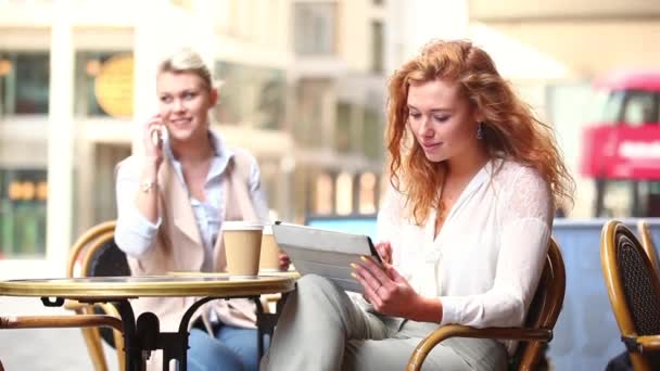 Mujeres en un café con sus teléfonos inteligentes — Vídeos de Stock