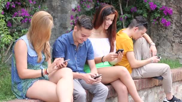 Grupp tonåringar skriver på sina telefoner — Stockvideo
