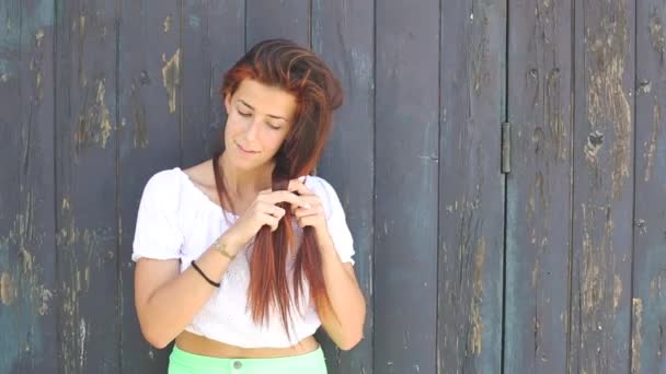 Ruiva menina trançando seu cabelo — Vídeo de Stock