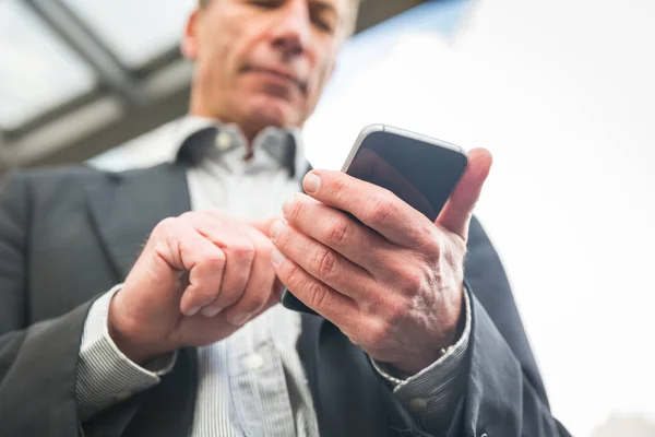 Üzletember keres és gépelés okos telefon — Stock Fotó