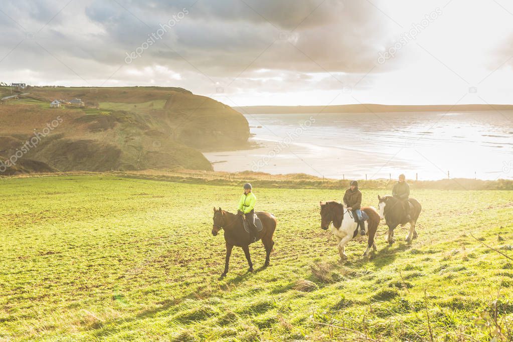 People riding horses in the countryside