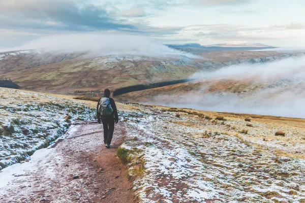 Homme marchant sur les collines enneigées en hiver — Photo