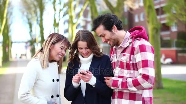 Grupo de amigos olhando para um telefone inteligente — Vídeo de Stock