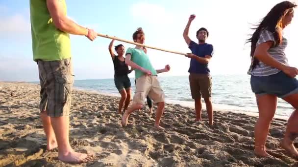 Amigos dançando Limbo na praia — Vídeo de Stock