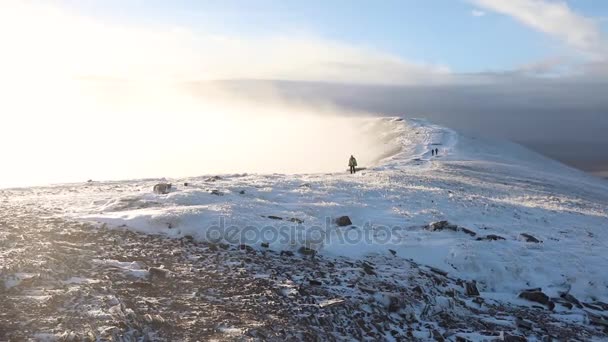 Gente caminando sobre la nieve en un sendero de montaña — Vídeo de stock