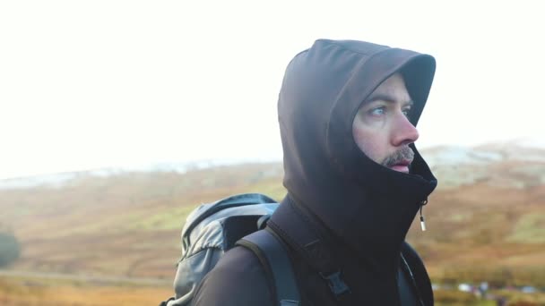 Чоловічий портрет зі засніженими пагорбами на фоні — стокове відео