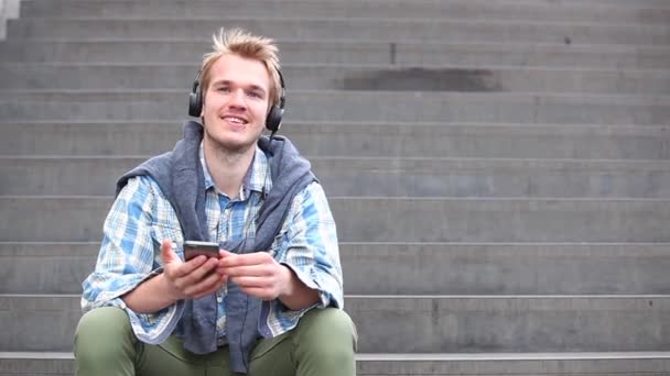 Junger Mann entspannt sich und hört Musik — Stockvideo