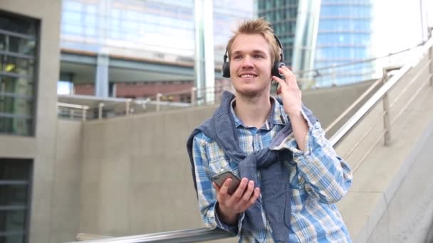 Молодий чоловік розслабляється і слухає музику — стокове відео