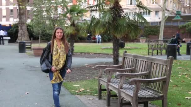 Junge Frau spaziert durch Park in London — Stockvideo