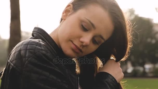 Chica haciendo una trenza con pelo en el parque — Vídeo de stock