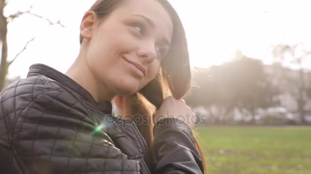 Chica haciendo una trenza con pelo en el parque — Vídeos de Stock