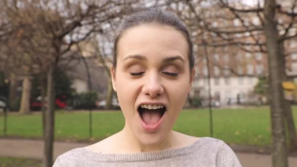 Портрет девушки, которая корчит рожи и меняет выражение лица — стоковое видео