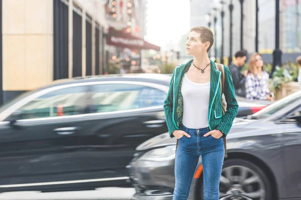 Frau in der Stadt mit verschwommenem Auto im Hintergrund — Stockfoto