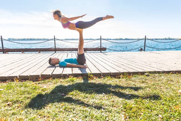 Kinesiskt par öva akrobatisk yoga på park i Toronto — Stockfoto