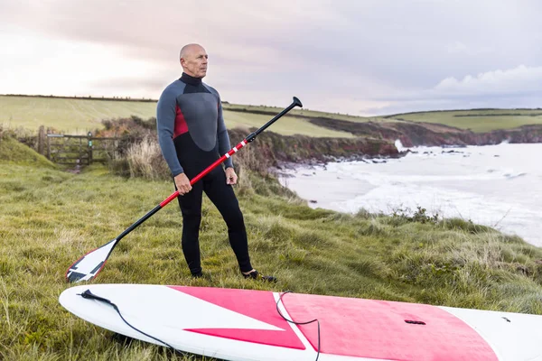Man met paddle Board over de kliffen — Stockfoto