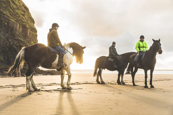 Emberek lovak a tengerparton egy felhős napon — Stock Fotó