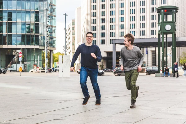 Dois homens brincando e correndo na cidade — Fotografia de Stock