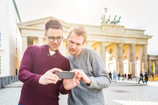 Två män tittar på en smartphone i Berlin — Stockfoto