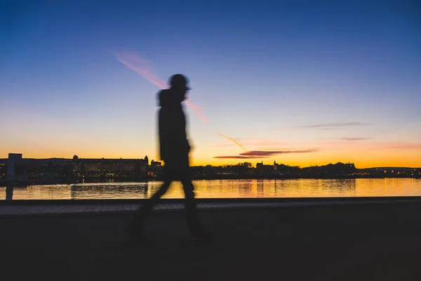 Silueta de un hombre caminando en Oslo al atardecer — Foto de Stock