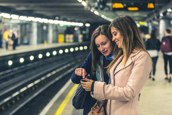 Deux filles dans le métro londonien attendant le train . — Photo