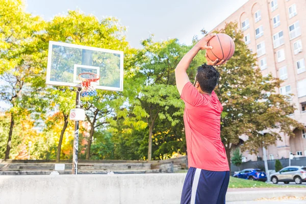 Man playing basket at outdoor court