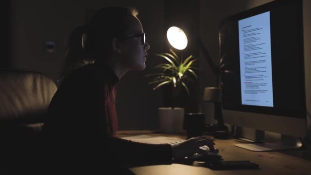 Jovem mulher trabalhando na estação de computador em casa — Vídeo de Stock