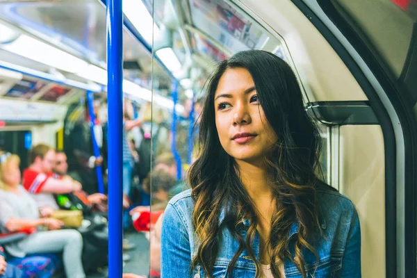 Asiatisk kvinna på tuben i London — Stockfoto