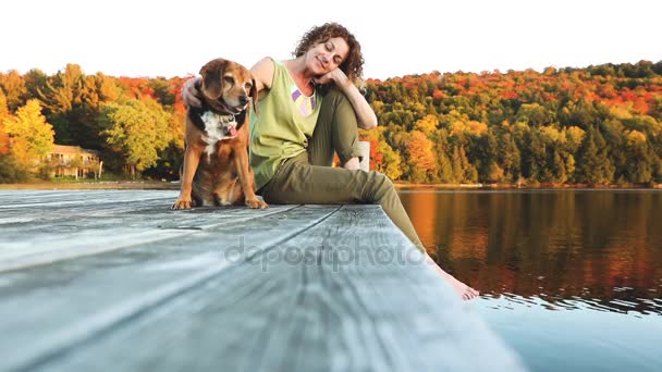 Woman and dog relaxing on the dock — Stock Video