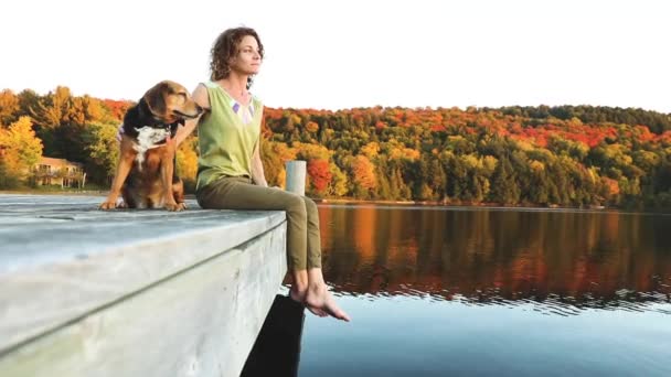 Mulher e cão relaxando na doca — Vídeo de Stock