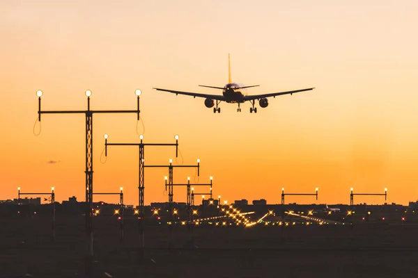 Airplane landing at sunset, silhouette — Stock Photo, Image