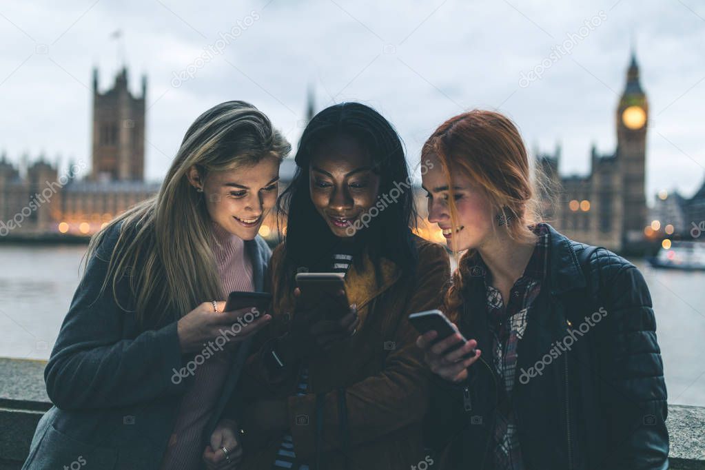 Best friends girls with smartphones in London