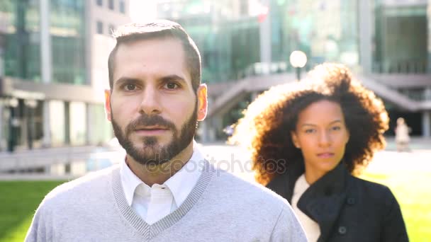 Портрет делового мужчины с женщиной на заднем плане, замедленная съемка — стоковое видео