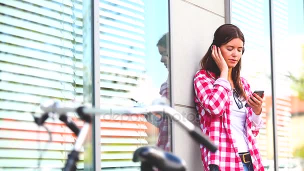 Femme écoutant de la musique avec casque dans la ville — Video