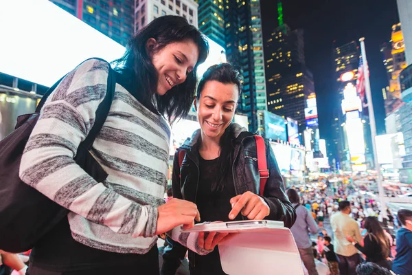Девушки в Нью-Йорке ночью смотрят на смартфон — стоковое фото