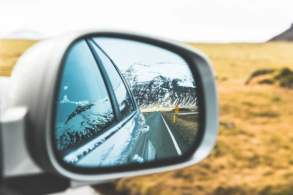 Snow and mountains view on wing mirror — Stock Photo, Image