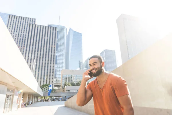 Черный мужчина говорит по телефону в городе — стоковое фото