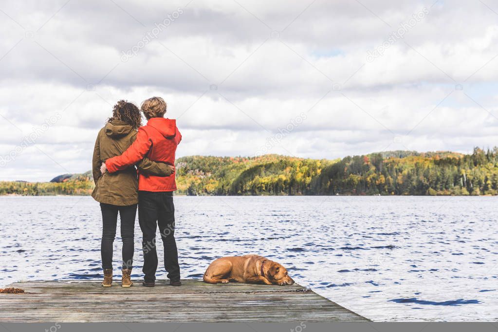Couple on the dock with a dog, looking at view
