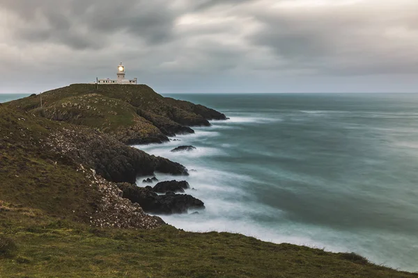 Moody seascape a világítótorony a sziklák — Stock Fotó