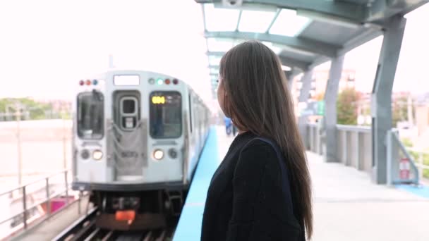 Девушка ждет поезда и улыбается, замедленная съемка — стоковое видео