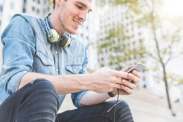 Homme avec téléphone et écouteurs, milieu urbain de la ville — Photo