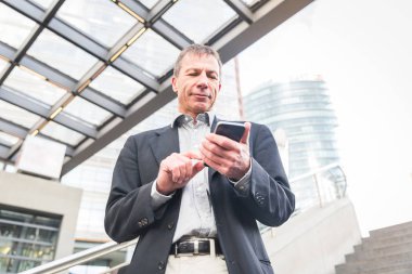 Akıllı telefon, modern şehir ayarları yazarak işadamı