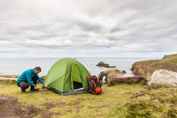 Man set up a tent on top of cliffs — Stock Photo, Image