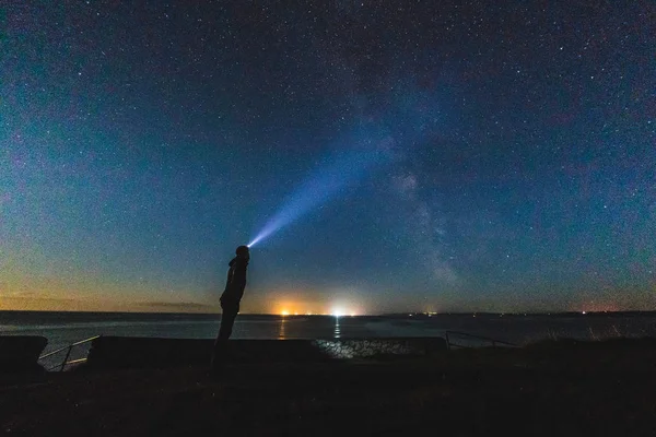 Homem com farol olhando para o céu noturno — Fotografia de Stock