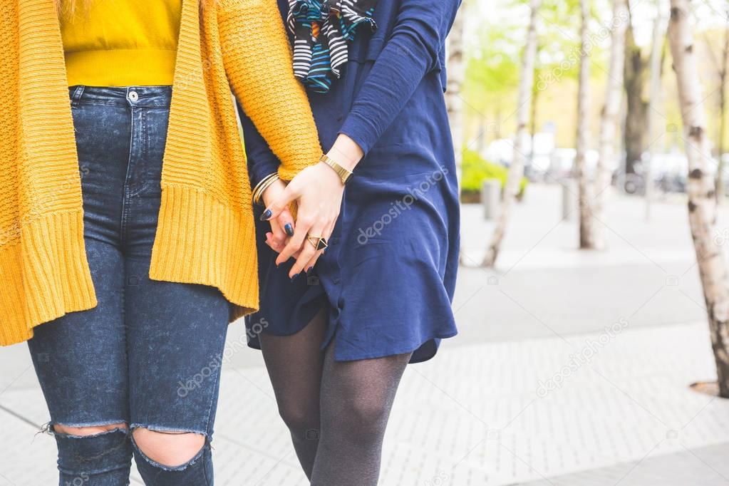 Lesbian couple holding hands and walking