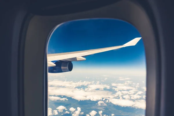 Ventana del avión y vista del ala volando sobre las nubes — Foto de Stock