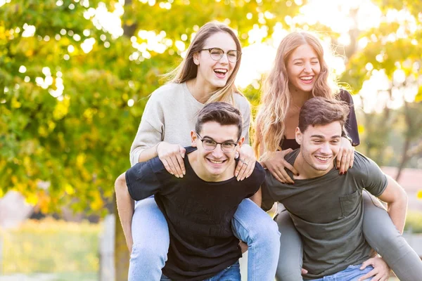 Teen friends at park having fun with piggyback ride — Stock Photo, Image