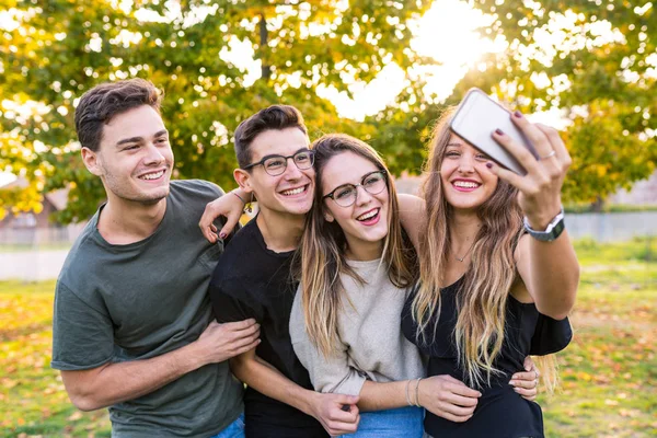 Adolescentes amigos no parque tomando uma selfie e se divertindo — Fotografia de Stock