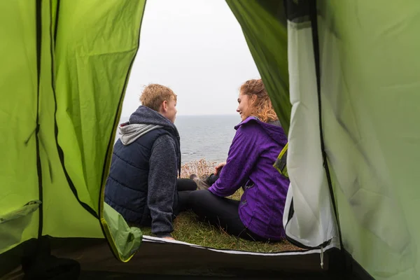 Boy and woman talking, view from inside a tent — Stock Photo, Image